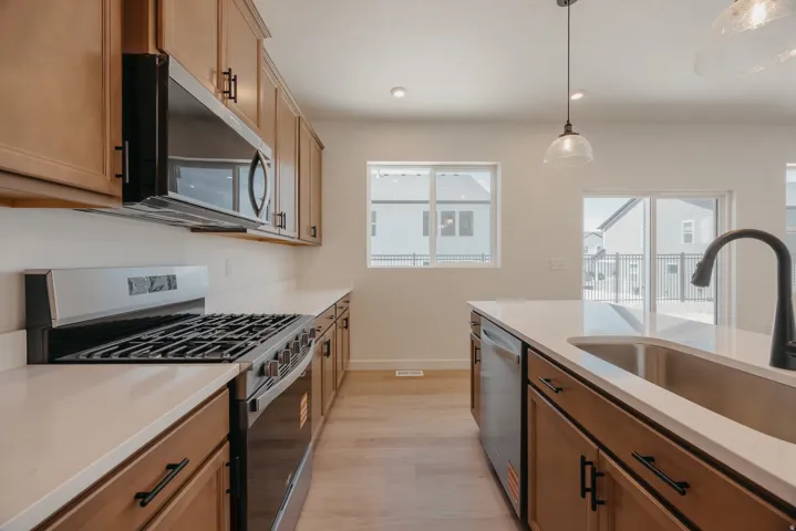 Contemporary kitchen featuring light wood-finish cabinetry, light countertops, and light wood-finish flooring