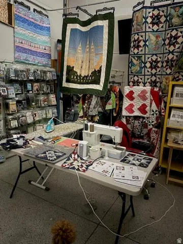 Workstation featuring a sewing machine, iron, and various crafting materials on a folding table