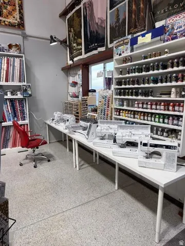 Spacious room featuring light speckled flooring and multiple white shelving units