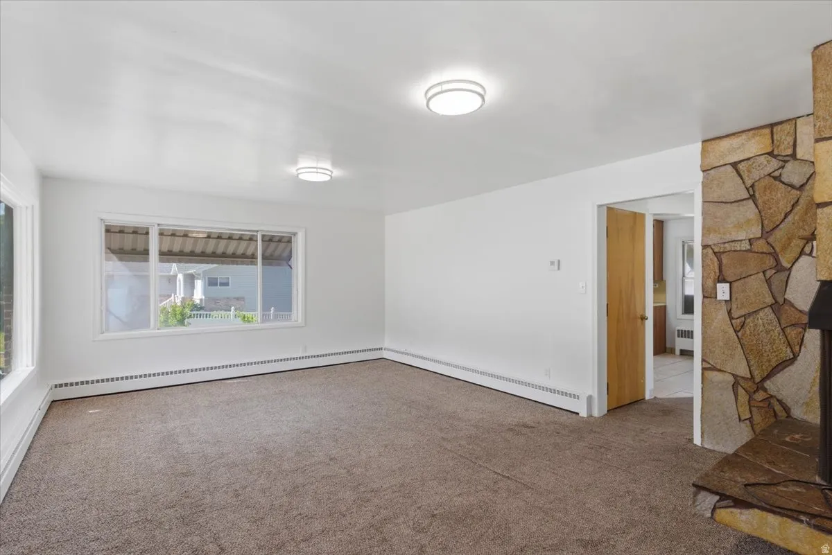 Spacious room featuring neutral carpeting and white walls