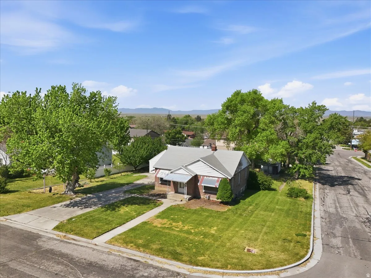 Traditional single-story residence featuring a gray gabled roof and brick siding with white trim