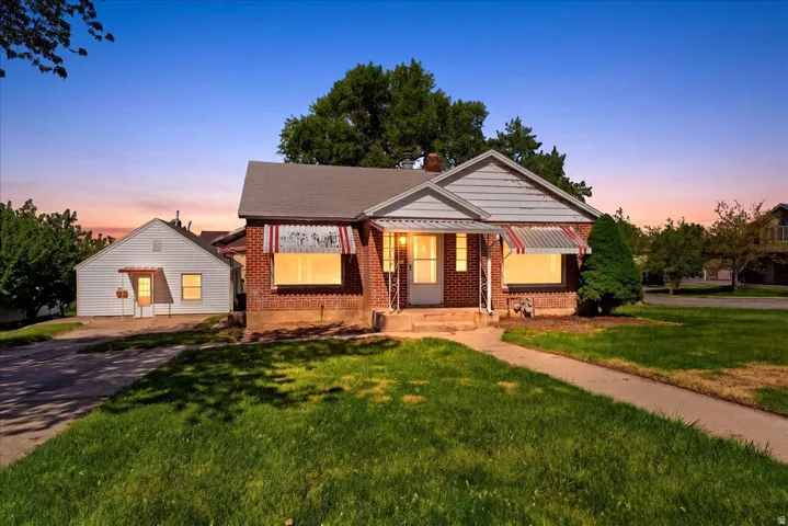 Brick residence featuring a covered front porch with decorative awnings