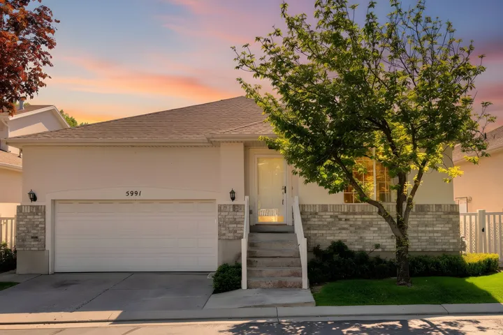 Contemporary facade featuring a light-toned stucco exterior with a complementary brick accent band