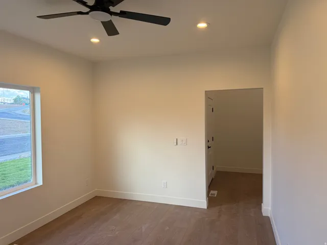 Recessed lighting, wood-finish flooring, and a ceiling fan with integrated lighting