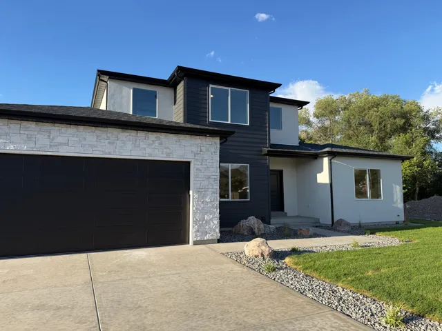 Modern exterior with a stone accent garage and a black sectional garage door