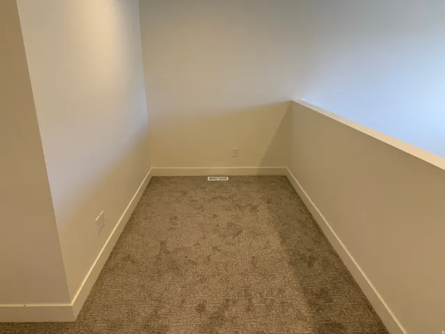 Carpeted nook with white walls and baseboards