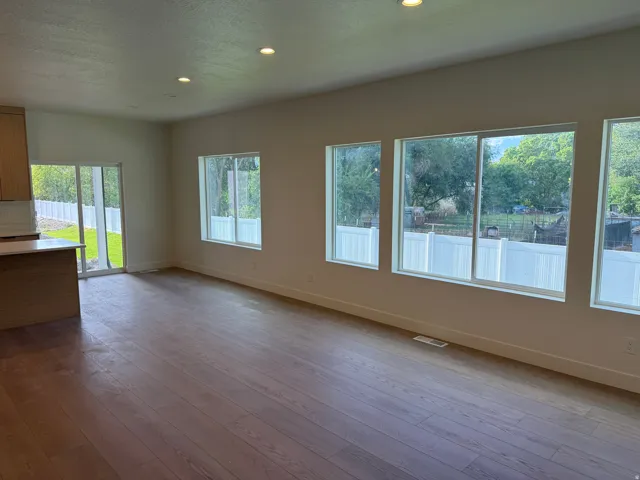 Wood-finish flooring throughout, recessed lighting, and multiple windows with white trim