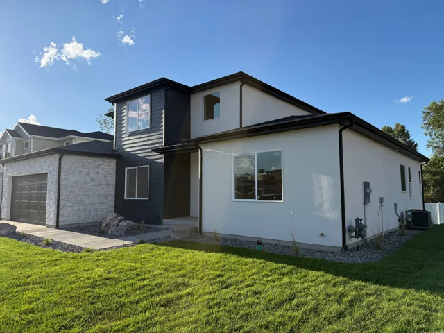 Contemporary exterior with mixed siding, stone facade garage, and dark trim