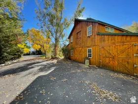Barn-style structure with wood siding and a dark green roof