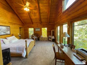 Expansive room featuring natural wood-finish walls and vaulted ceilings with exposed beams