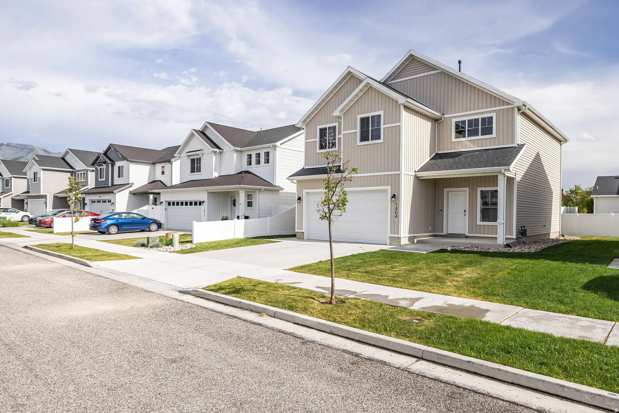 Contemporary two-story residence featuring light beige siding and a dark shingle roof