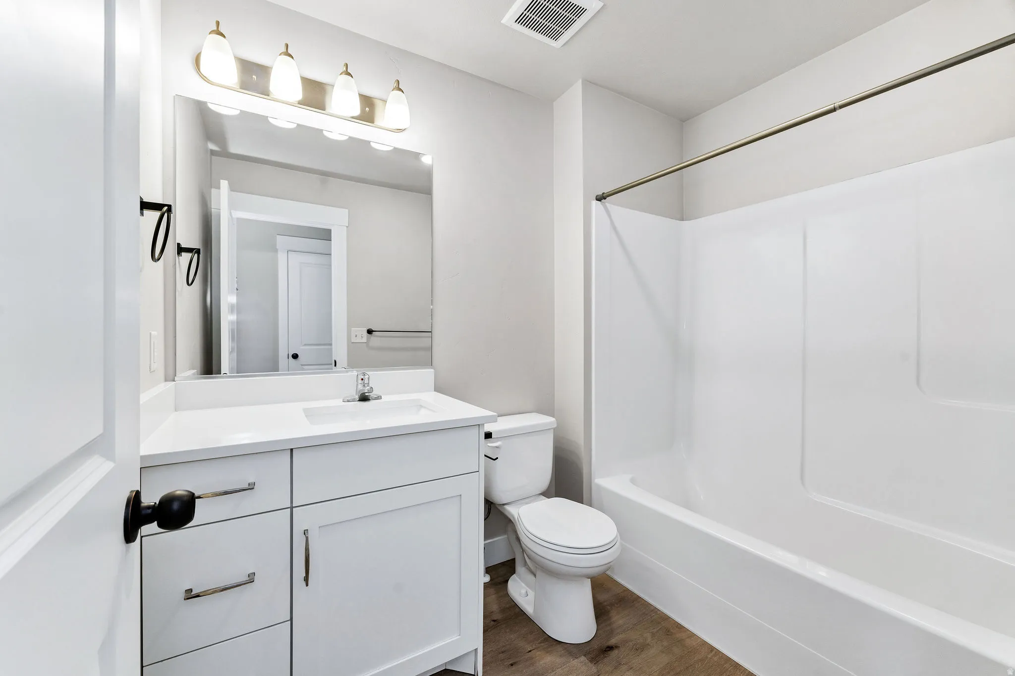 Bathroom featuring a white vanity with a countertop, undermount sink, and chrome faucet