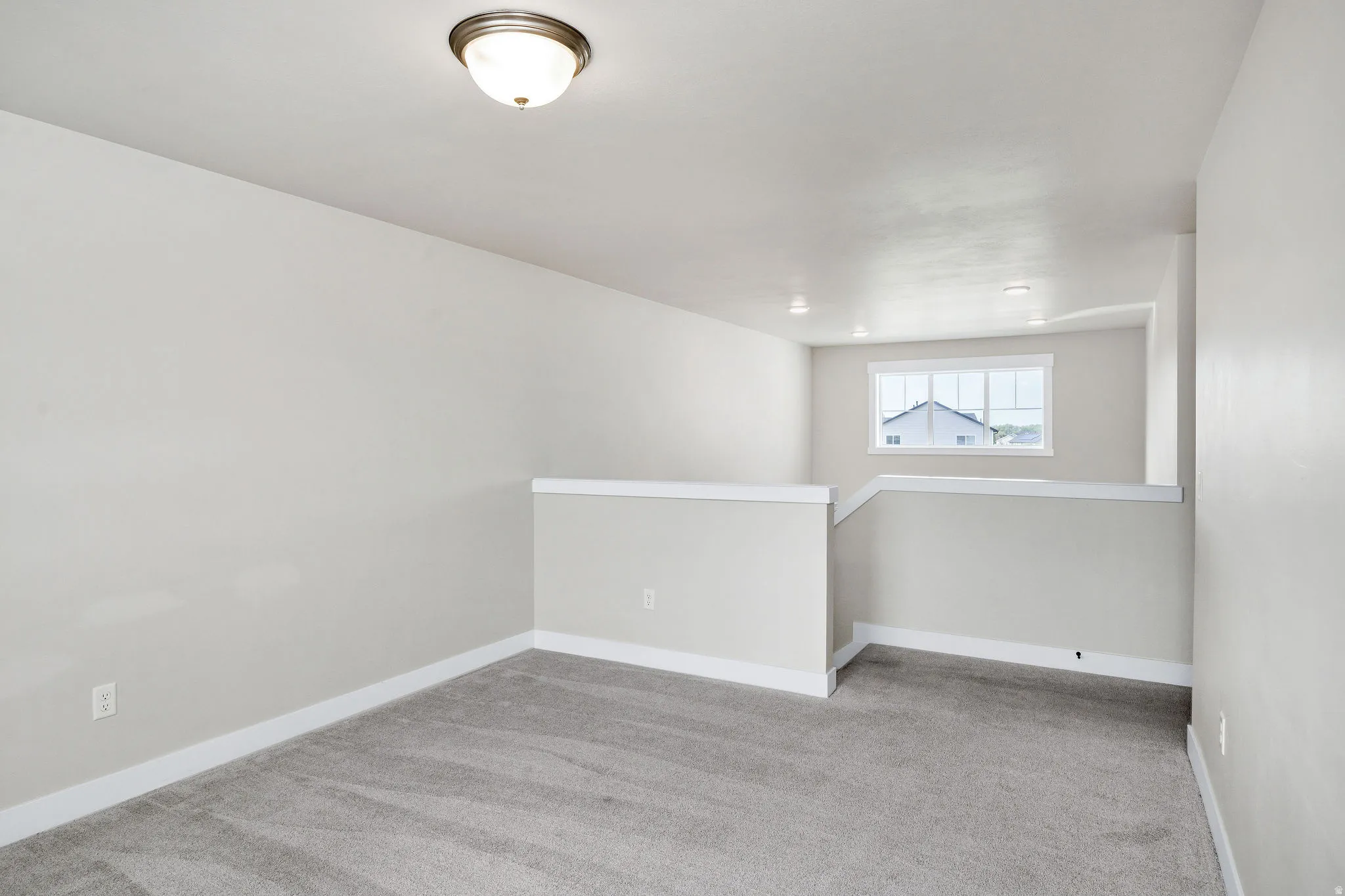 Carpeted loft area featuring neutral wall paint, white trim, and a window