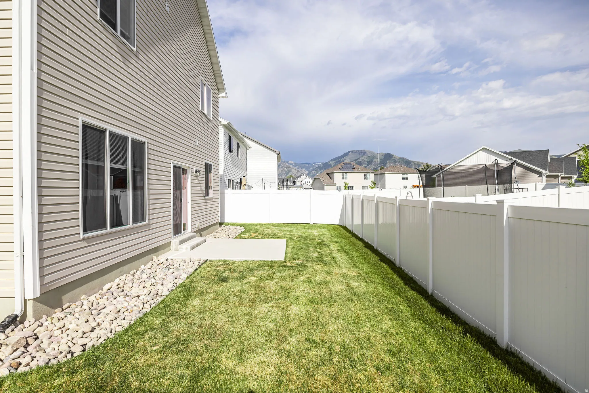 Expansive green lawn with a white vinyl fence