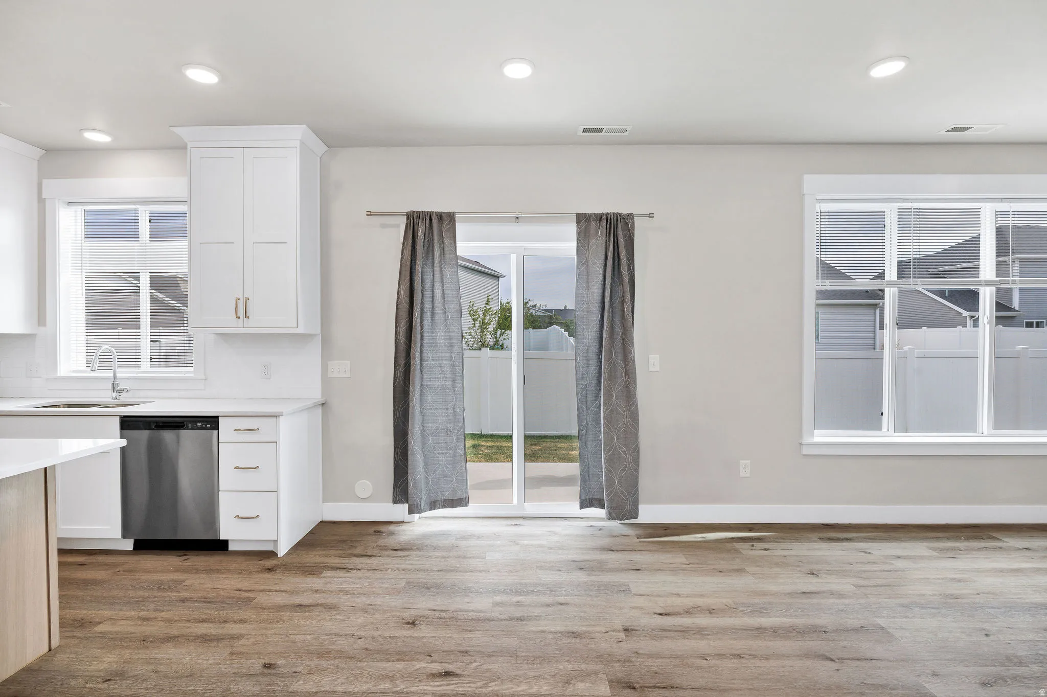 Open-concept interior featuring wood-finish flooring, recessed lighting, and a modern kitchen area