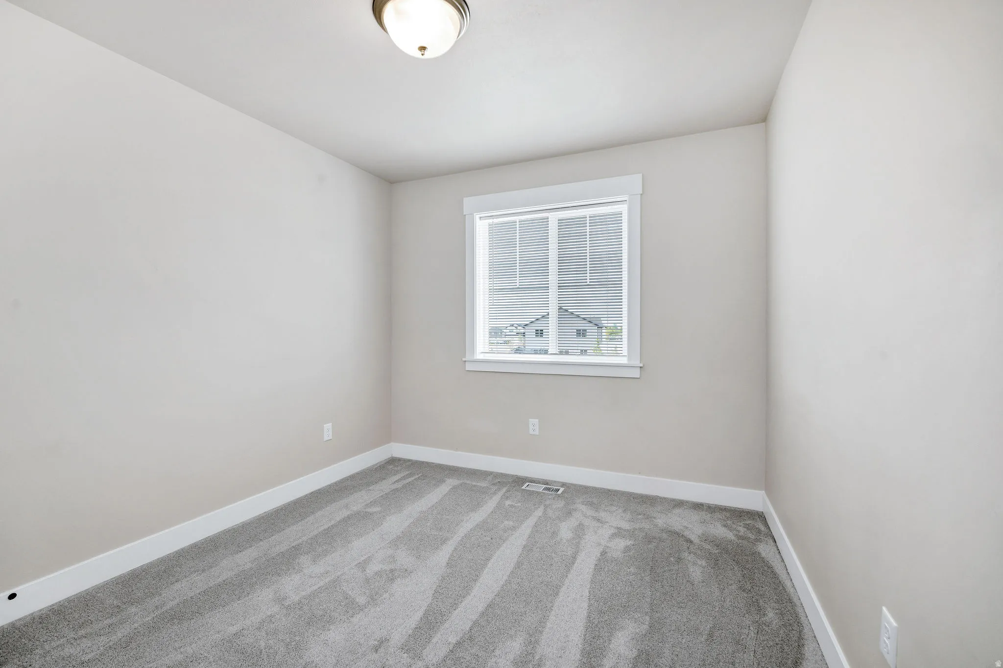 Neutral-toned walls complement the gray patterned carpet in this room