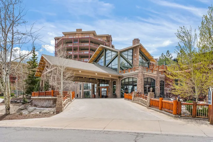 Grand lodge-style building featuring a stone and wood exterior with expansive windows