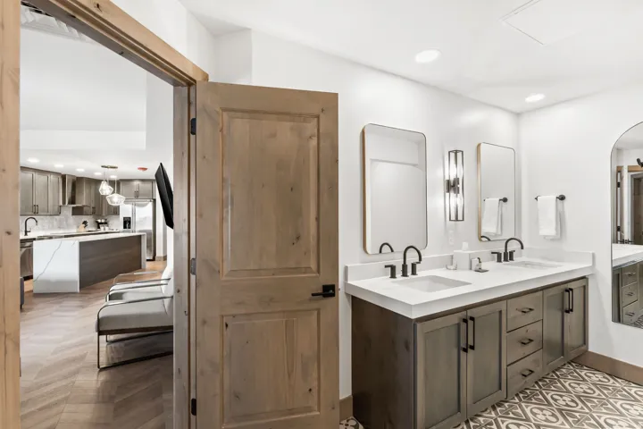 Contemporary bathroom featuring a double vanity with matte black fixtures and a patterned tile floor