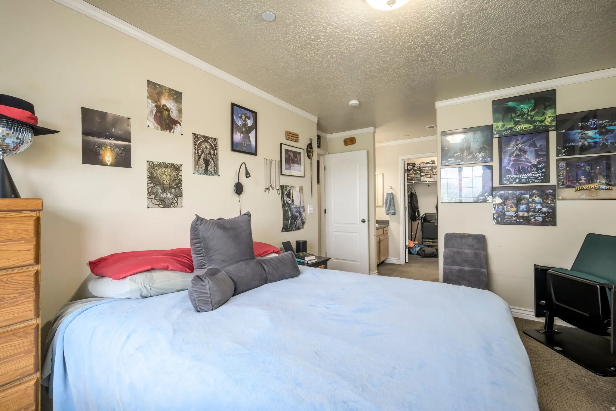 Carpeted bedroom featuring neutral wall tones, crown molding, and a built-in closet with shelving