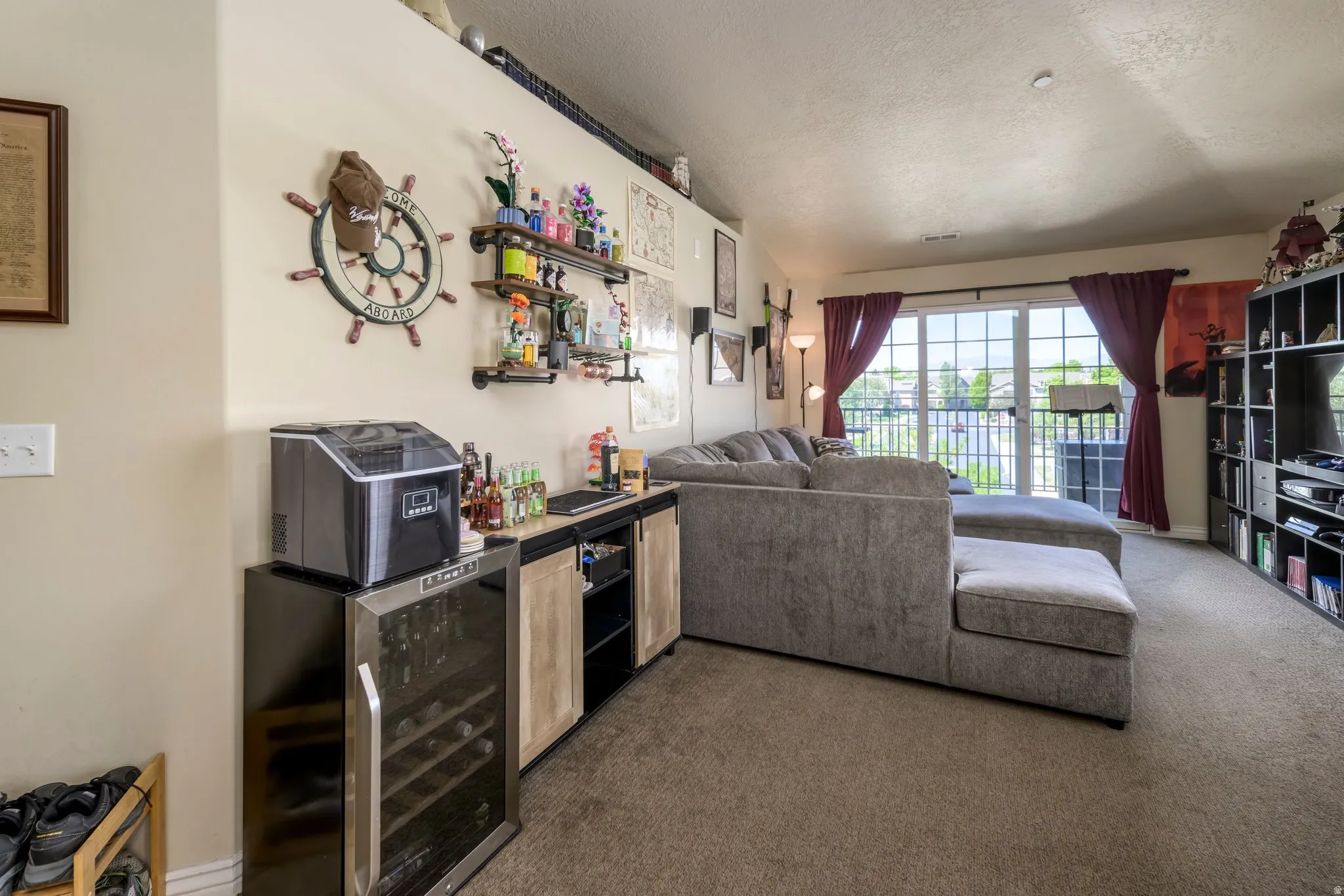Spacious living area featuring neutral carpet flooring and a built-in shelving unit