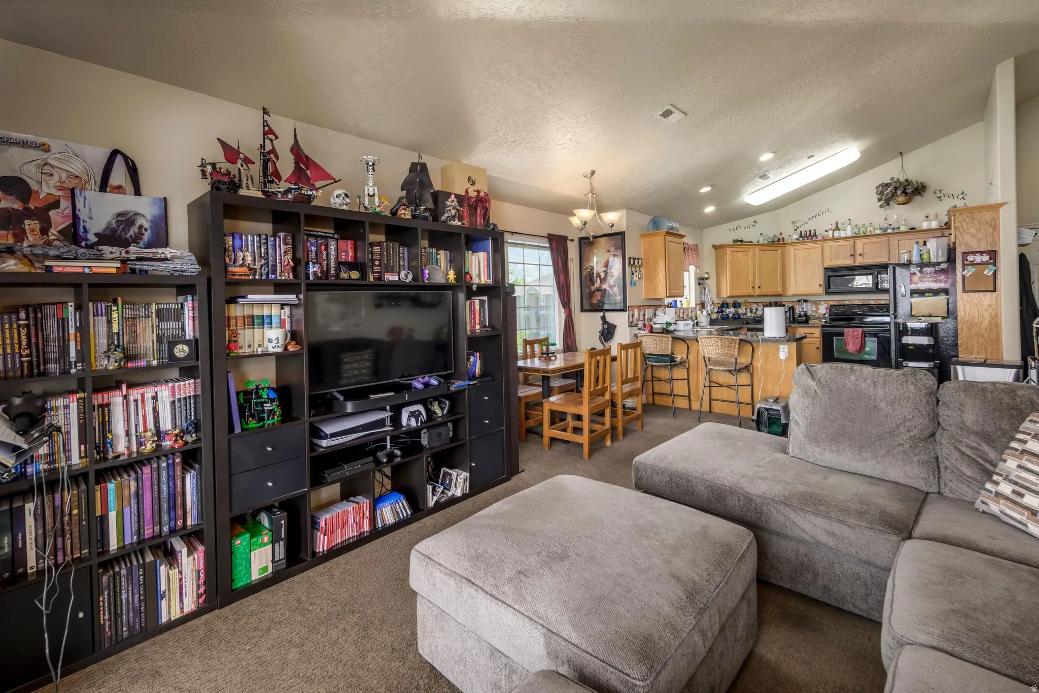 Open-concept living space featuring a vaulted ceiling and carpet flooring