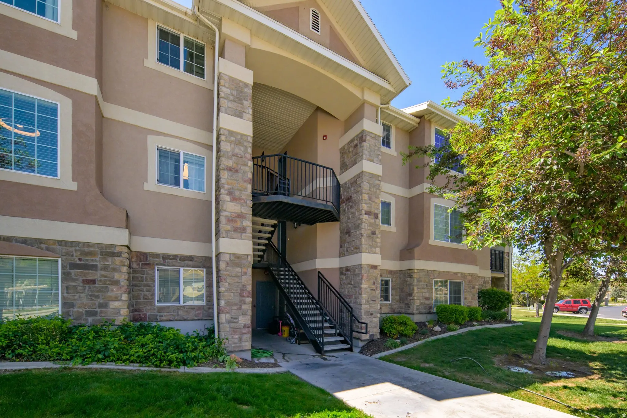 Multi-story property featuring a stucco and stone veneer exterior