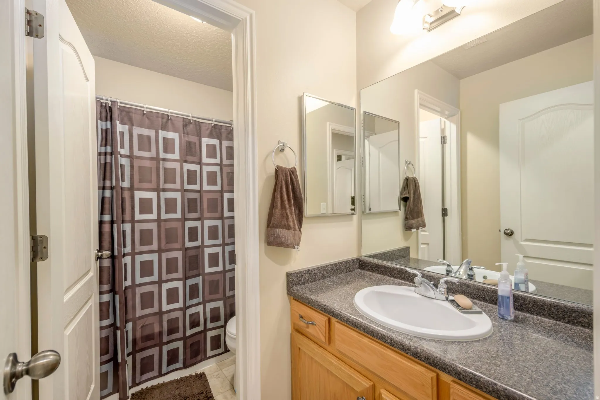 Bathroom vanity featuring a single basin sink and speckled countertop