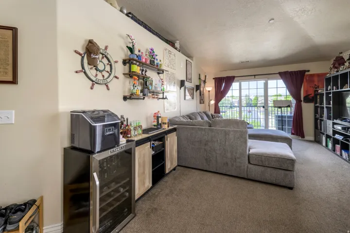 Spacious living area featuring neutral carpet flooring and a built-in shelving unit