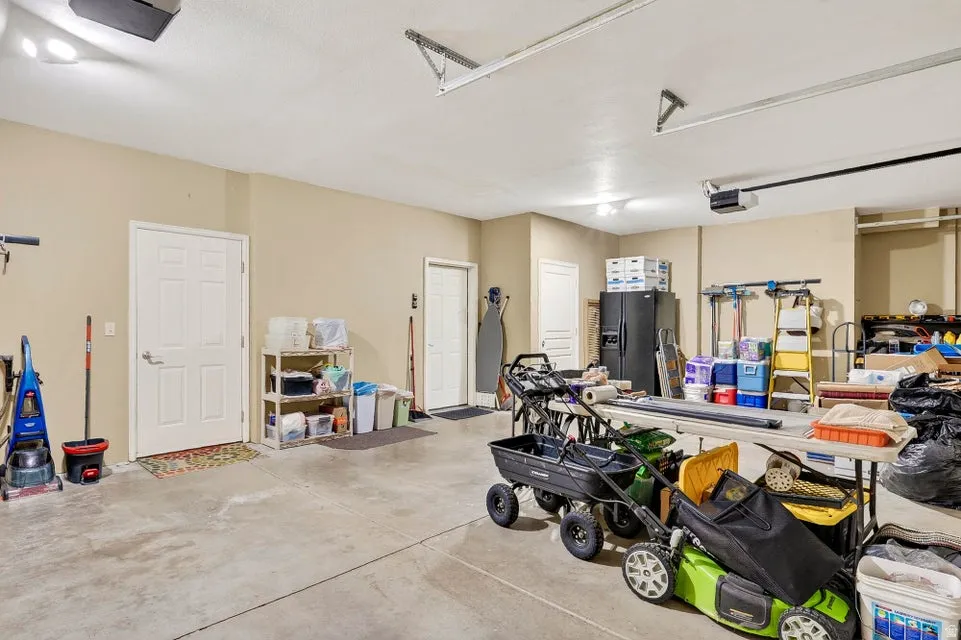 Spacious garage featuring a concrete floor, light neutral wall paint, and multiple white panel doors