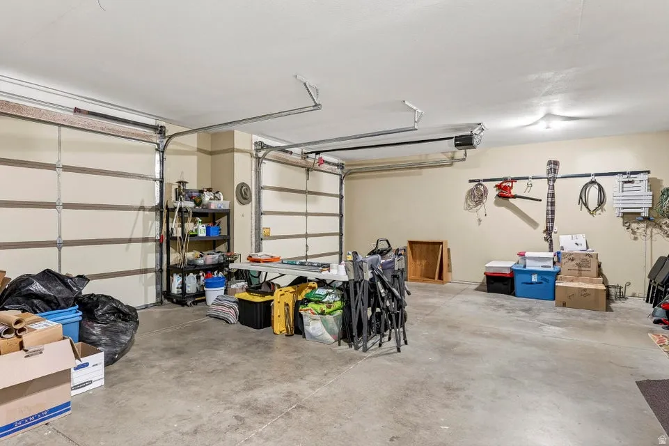Spacious two-car garage featuring segmented garage doors, concrete flooring, and ample wall space for organization