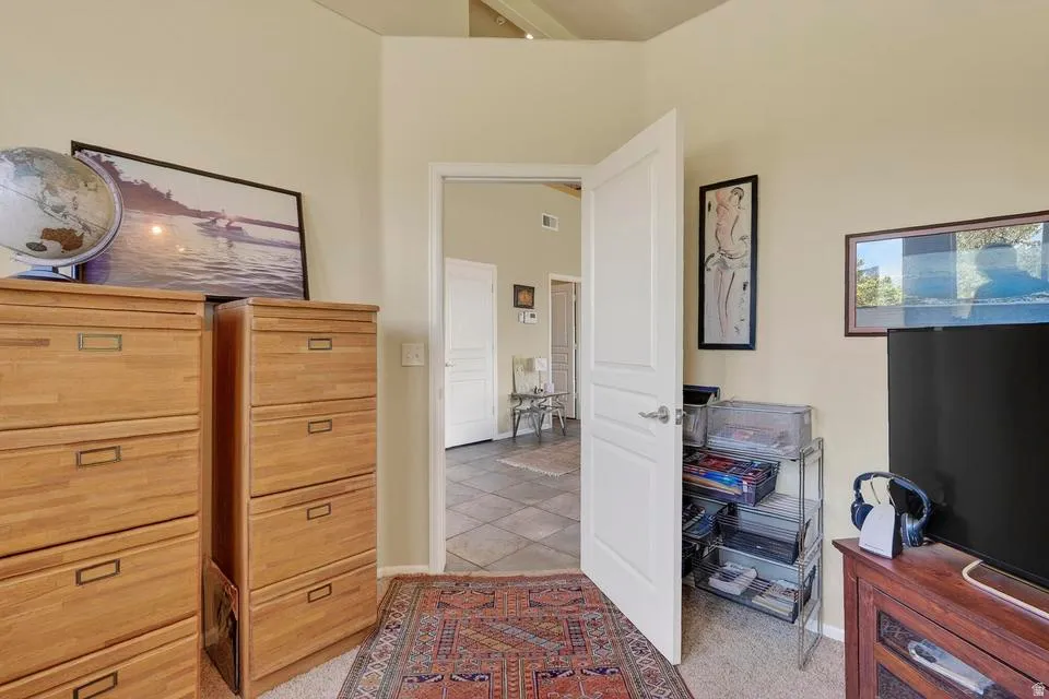 Interior space featuring vaulted ceilings, neutral wall tones, and light-toned carpeting