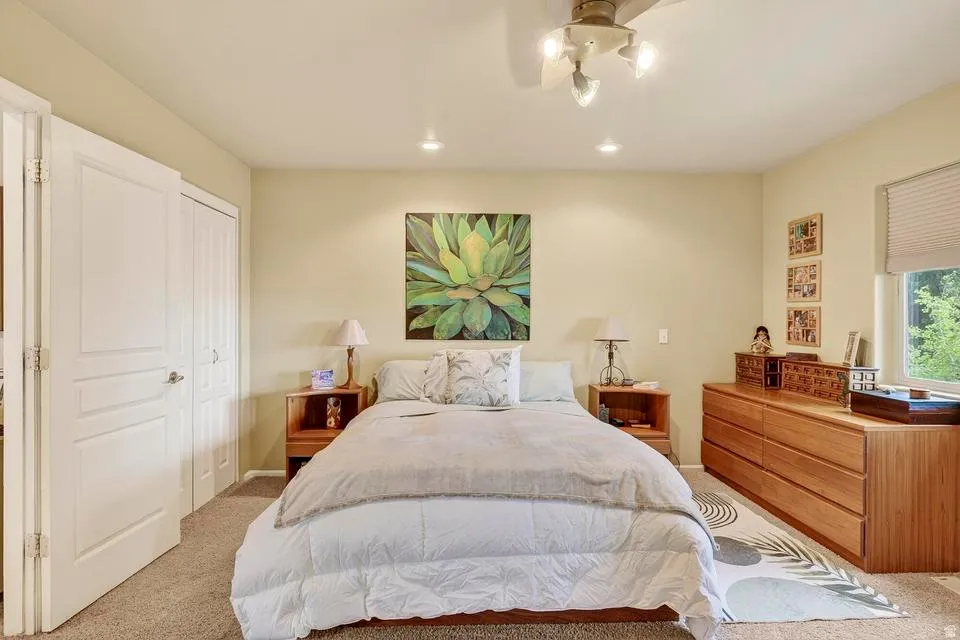 Carpeted bedroom featuring a ceiling fan with integrated lighting, recessed lighting, double-panel interior doors, and a window with blinds