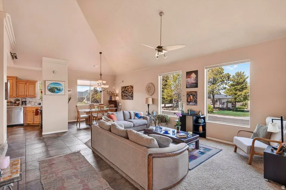 Vaulted ceilings highlight this living area featuring carpeting and large windows
