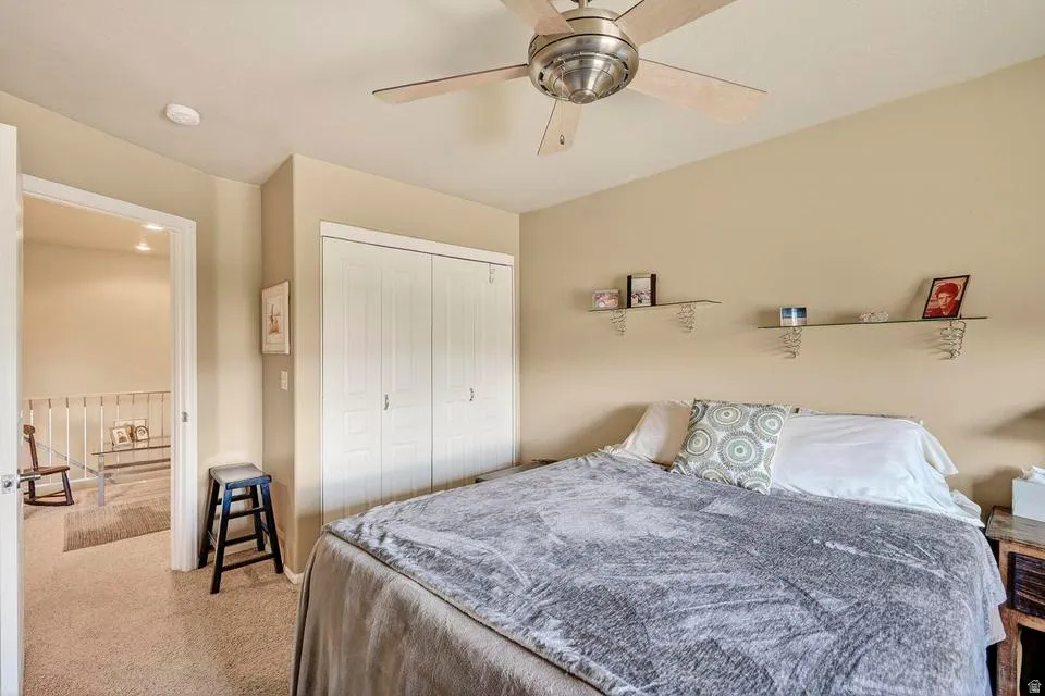 Carpeted interior with neutral wall finishes and a ceiling fan