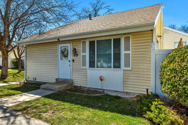 Ranch-style exterior featuring horizontal siding, a gabled roof, and a white entry door with a decorative glass insert
