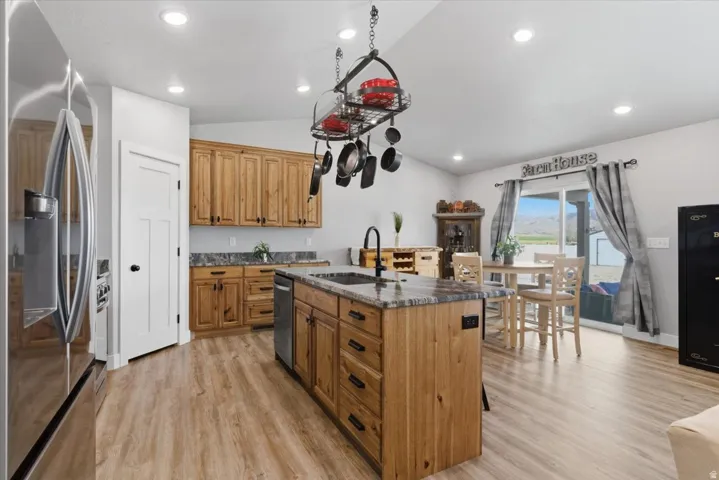 Spacious kitchen featuring wood-finish cabinetry, granite countertops, and wood-finish flooring
