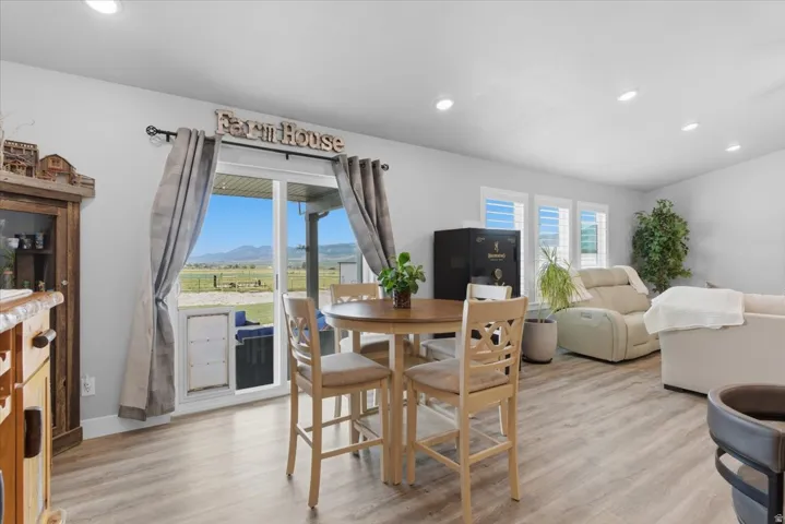 Open-concept living space featuring wood-finish flooring, recessed lighting, and white walls