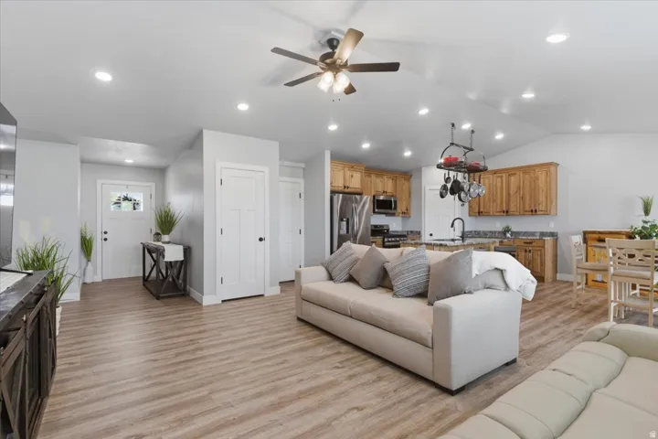 Open-concept living space featuring wood-finish flooring, recessed lighting, and a ceiling fan