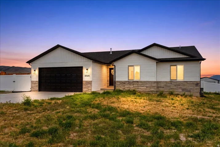 Ranch-style exterior featuring white siding and stone accents