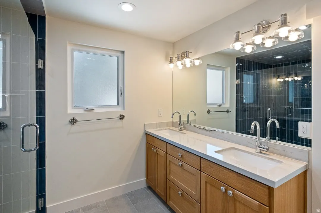 Dual vanity with integrated sinks and a light-toned countertop, set against wood-finish cabinetry