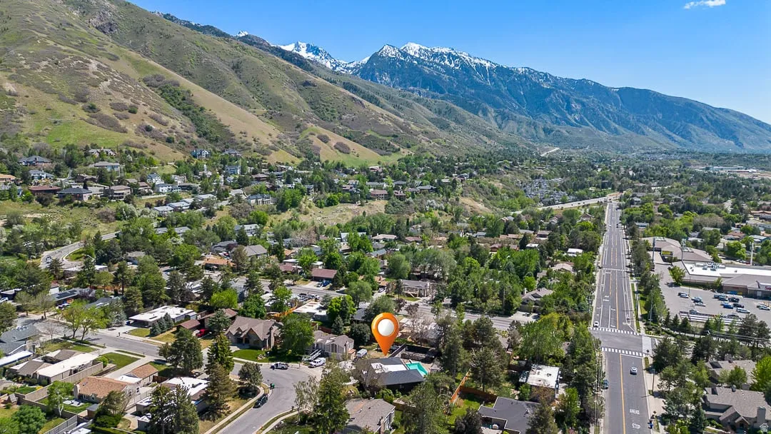 Residential property featuring an outdoor swimming pool, surrounded by mature trees and mountain scenery