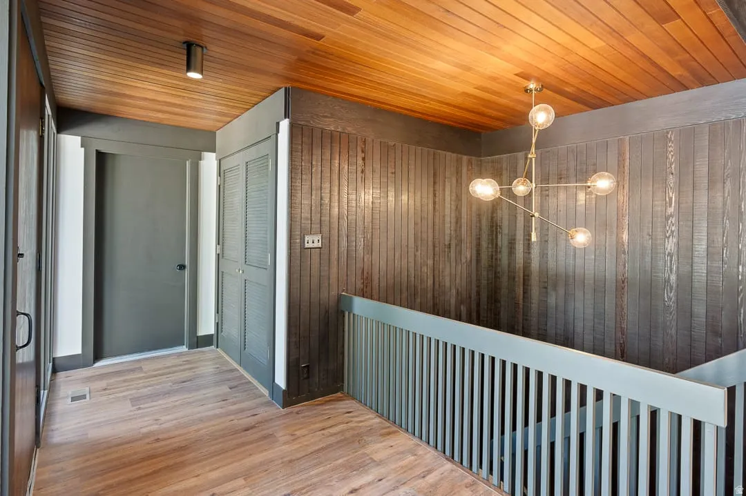 Wood-finish flooring extending into a hallway with a slatted wood ceiling