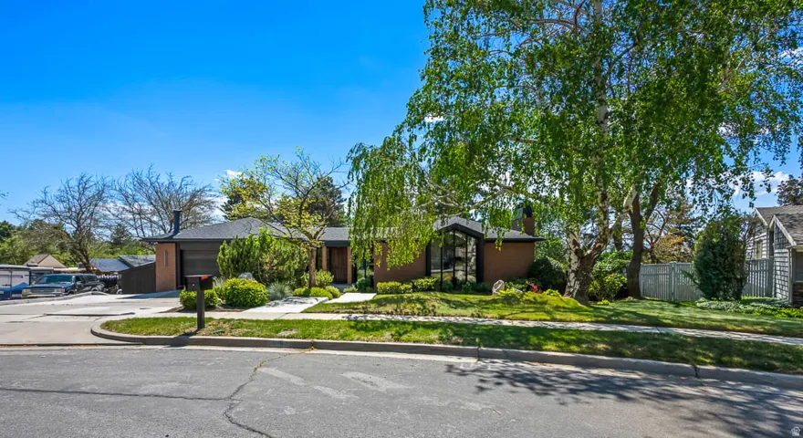 Brick exterior featuring a dark asphalt shingle roof, integrated garage, and a concrete driveway