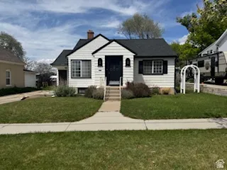 White exterior home featuring black shutters and a prominent front door
