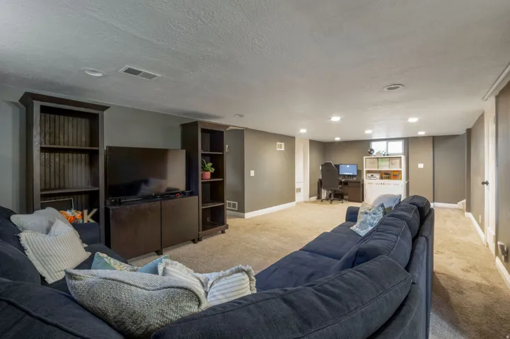 Spacious lower-level area featuring recessed lighting, a neutral carpeted floor, and painted walls