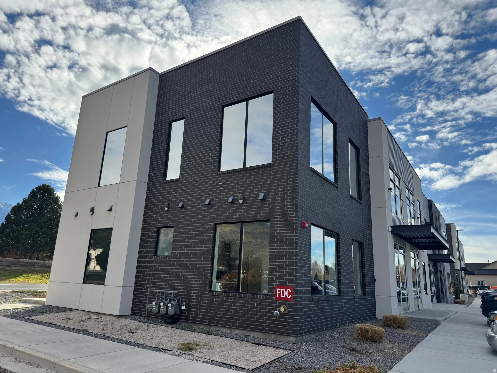 Modern commercial building featuring dark brick and light-colored paneling