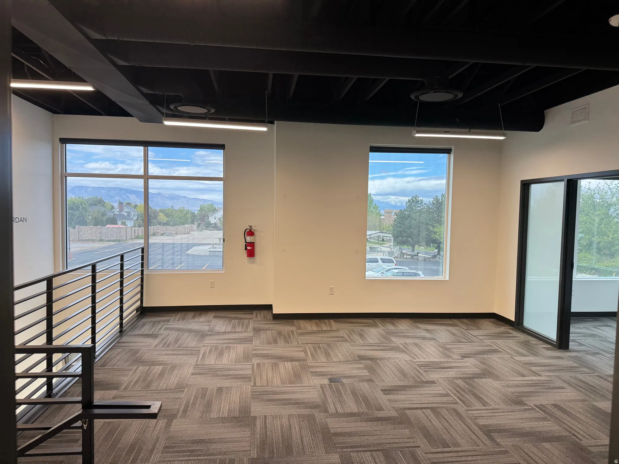 Spacious interior featuring a neutral color palette, exposed industrial-style ceiling, and modern linear lighting