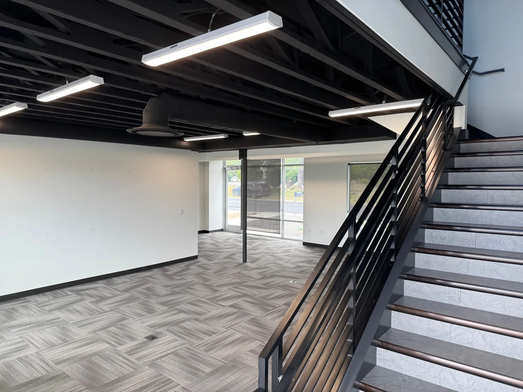 Modern commercial interior featuring an open-concept layout with large windows