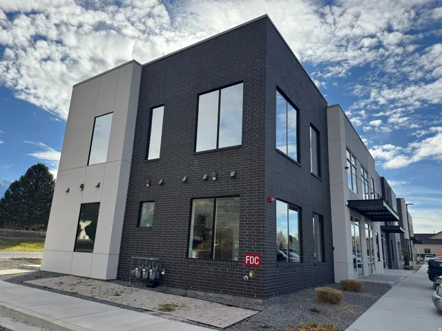 Modern commercial building featuring dark brick and light-colored paneling