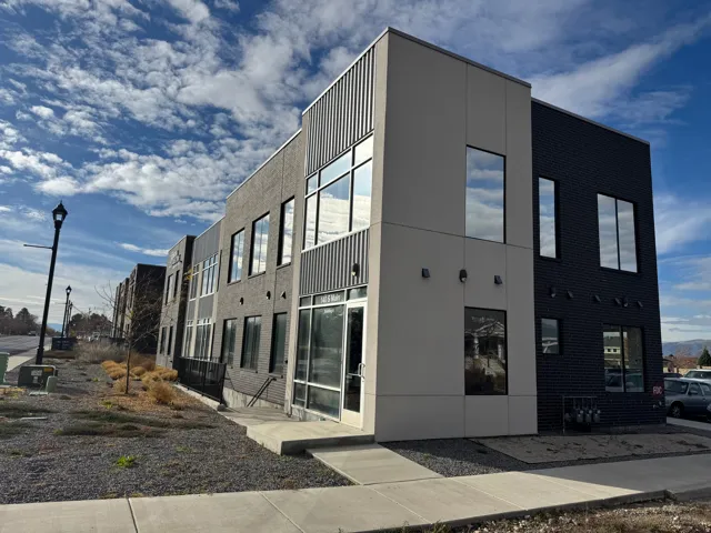 Modern commercial building featuring a multi-textured facade with dark brick and light-toned siding
